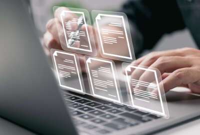Businessman working on laptop computer with electronics document icons, E-document management, online documentation database, paperless office concept