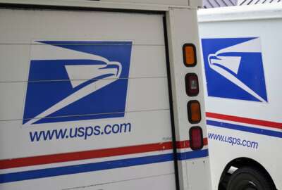 FILE - In this Aug. 18, 2020, file photo, mail delivery vehicles are parked outside a post office in Boys Town, Neb. The U.S. Postal Service says it has cleared the final regulatory hurdle to placing orders for next-generation mail vehicles. That keeps the Postal Service on track for taking delivery of the first of the electric- and gas-powered delivery vehicles next year. Postmaster General Louis DeJoy said Wednesday, Feb. 23, 2022 that the completion of an evaluation required by the National Environmental Policy Act is an important milestone for postal carriers who’ve soldiered on with overworked delivery trucks that went into service from 1987 to 1994. (AP Photo/Nati Harnik, File)